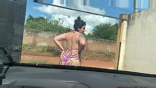 May canta sedutoramente em seu carro, atraindo os espectadores com sua performance tentadora.